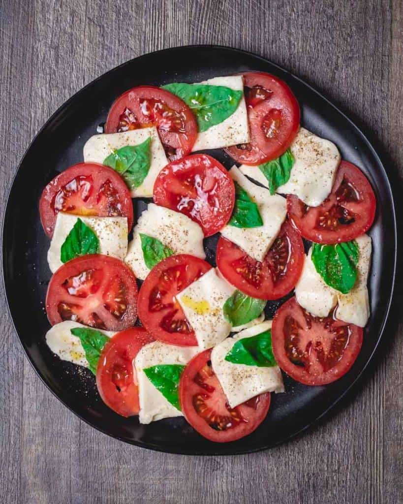 overhead shot of caprese salad on a black plate