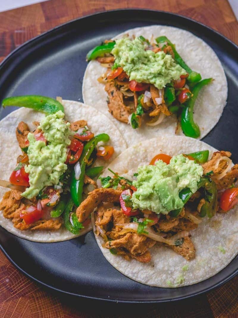 overhead shot of 3 soy curl carne asada tacos on a plate