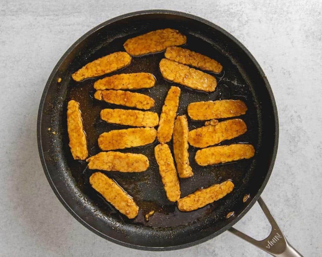 overhead shot of tempeh bacon marinating in pan