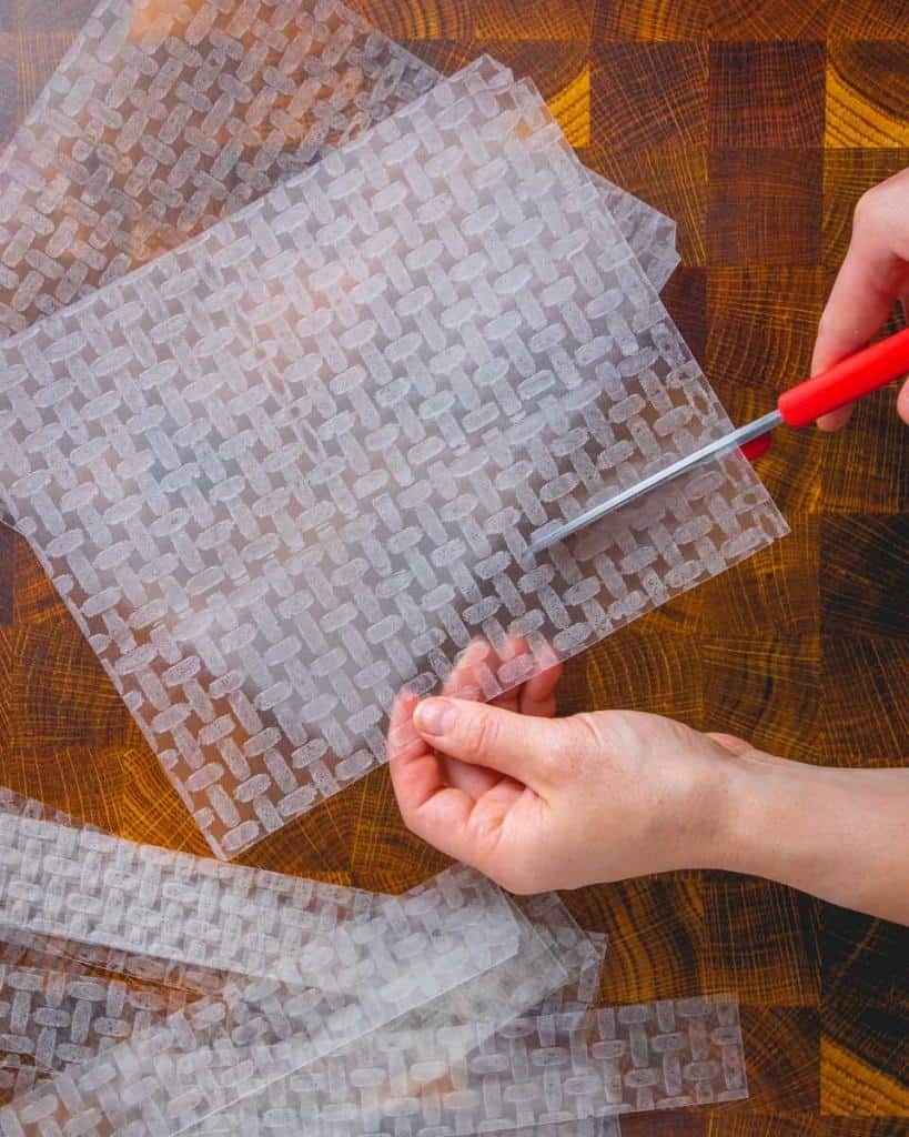 cutting sheets of rice paper with scissors