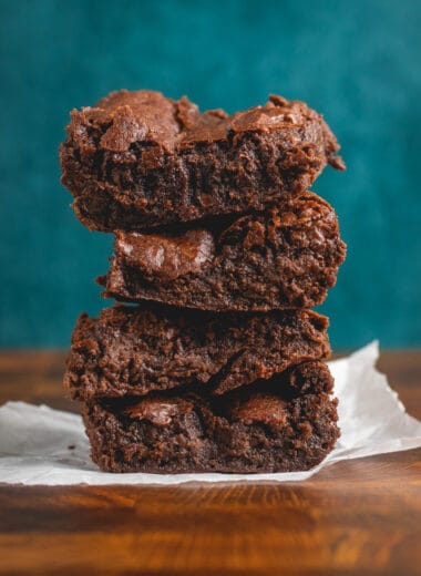 stack of vegan brownie slices on a piece of parchment