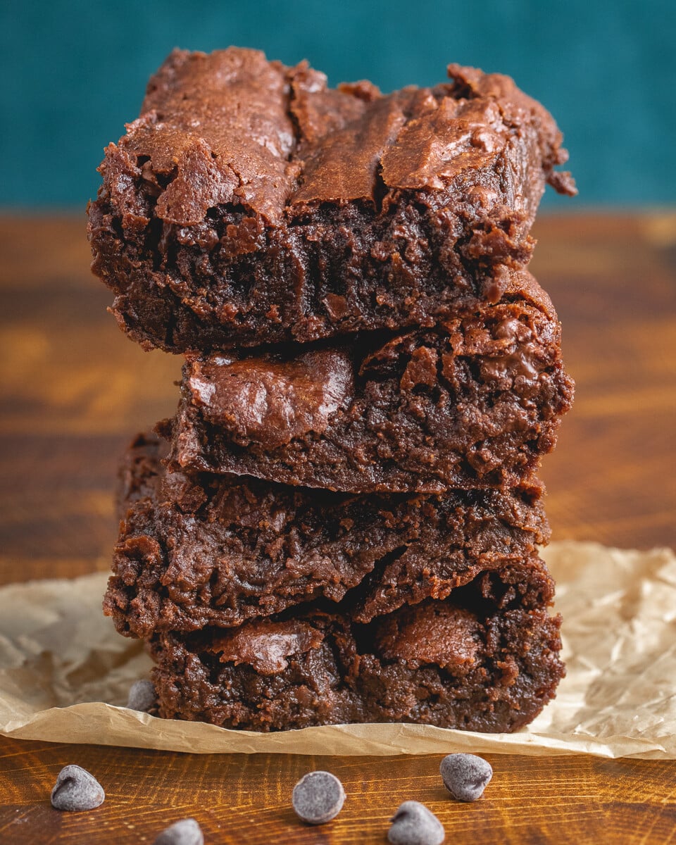 stack of vegan brownie slices on a piece of parchment