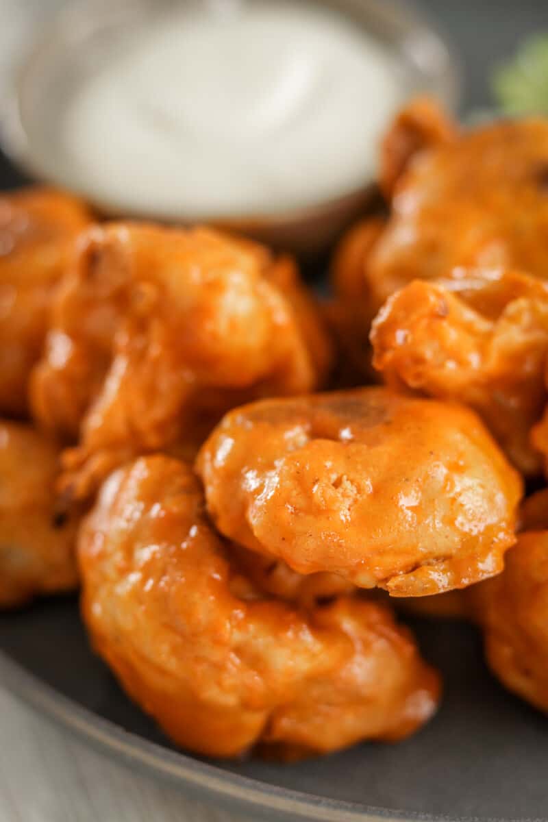 closeup shot of plated buffalo cauliflower wings on a plate with ranch dressing