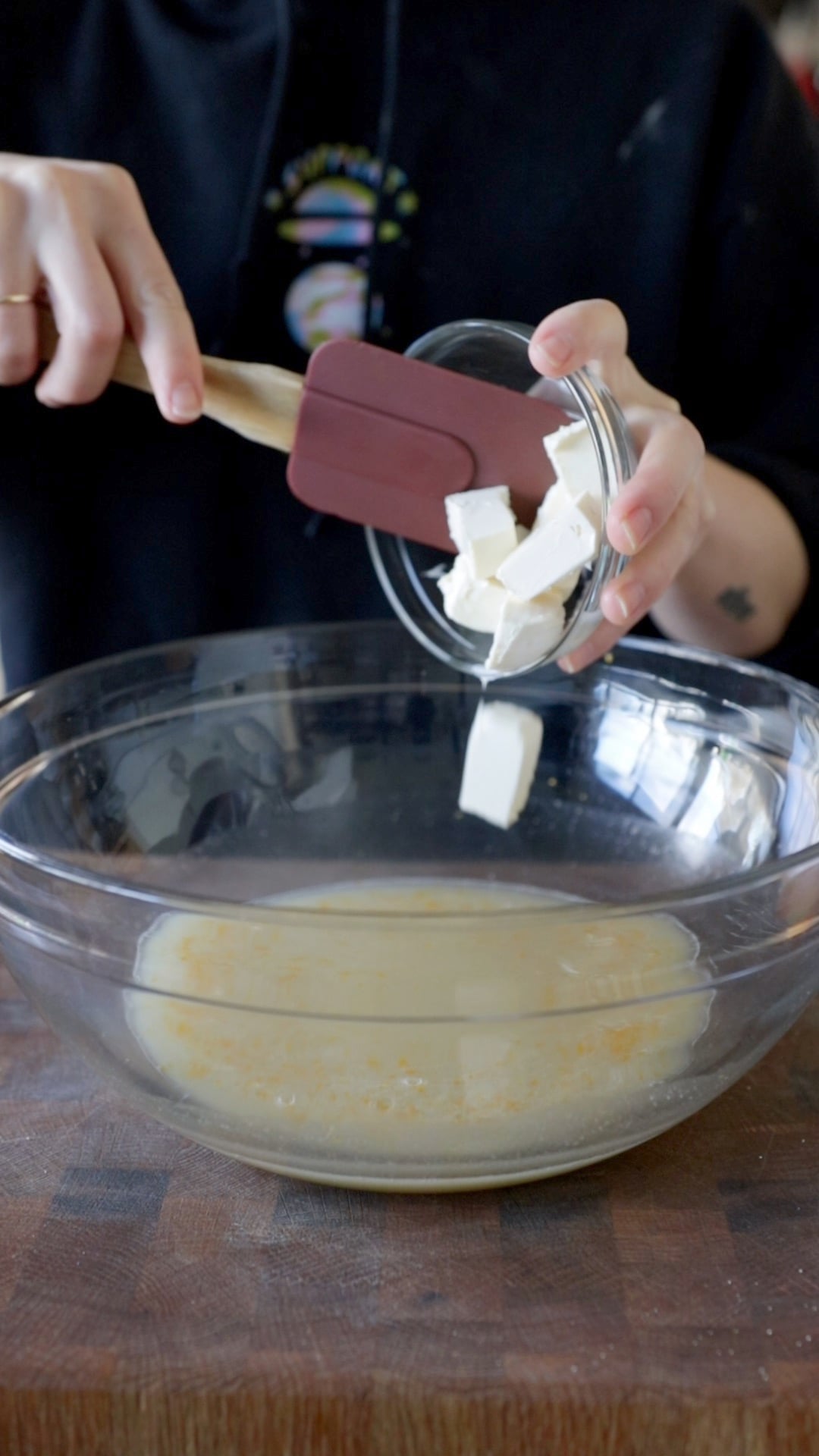 cubes of vegan butter getting put into a large glass mixing bowl