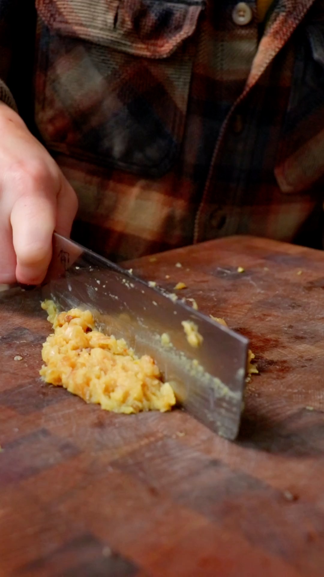 chopping roasted garlic on a cutting board