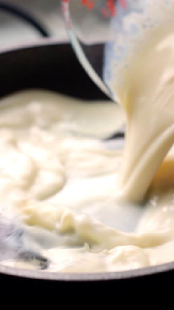 plant milk being poured into a small saucepan