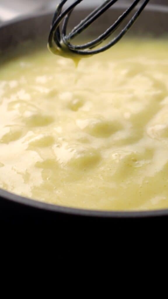 vegan yolk sauce simmering in a small saucepan