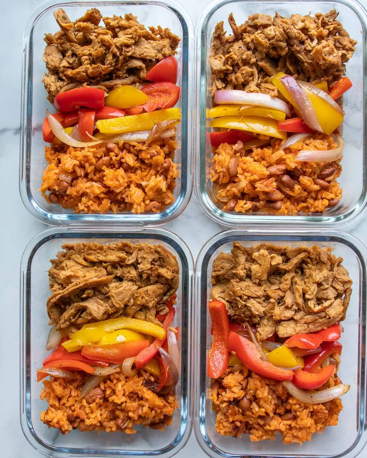 overhead of several containers of vegan fajita bowl meal prep
