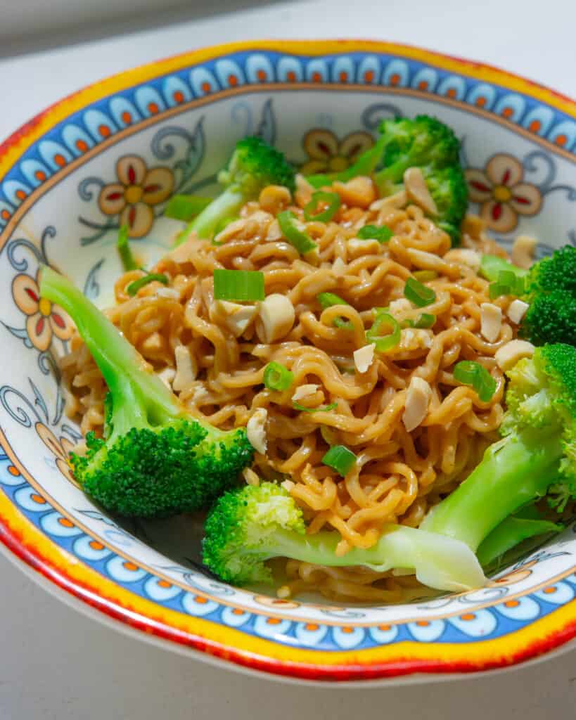 A close up shot of Peanut Butter Noodles in a bowl. The noodles are coated