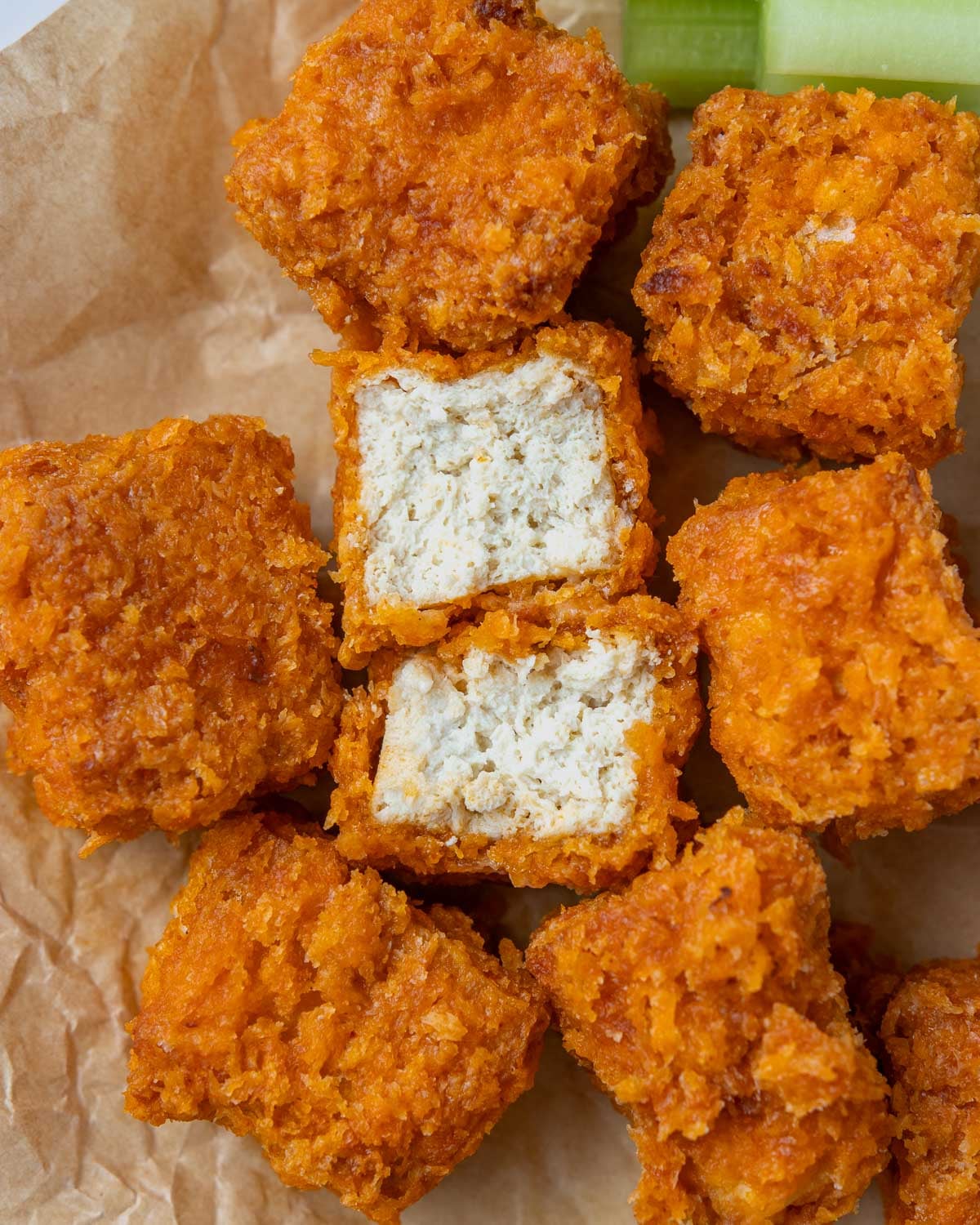 close up cross-section of a buffalo tofu cube, next to whole tofu bites