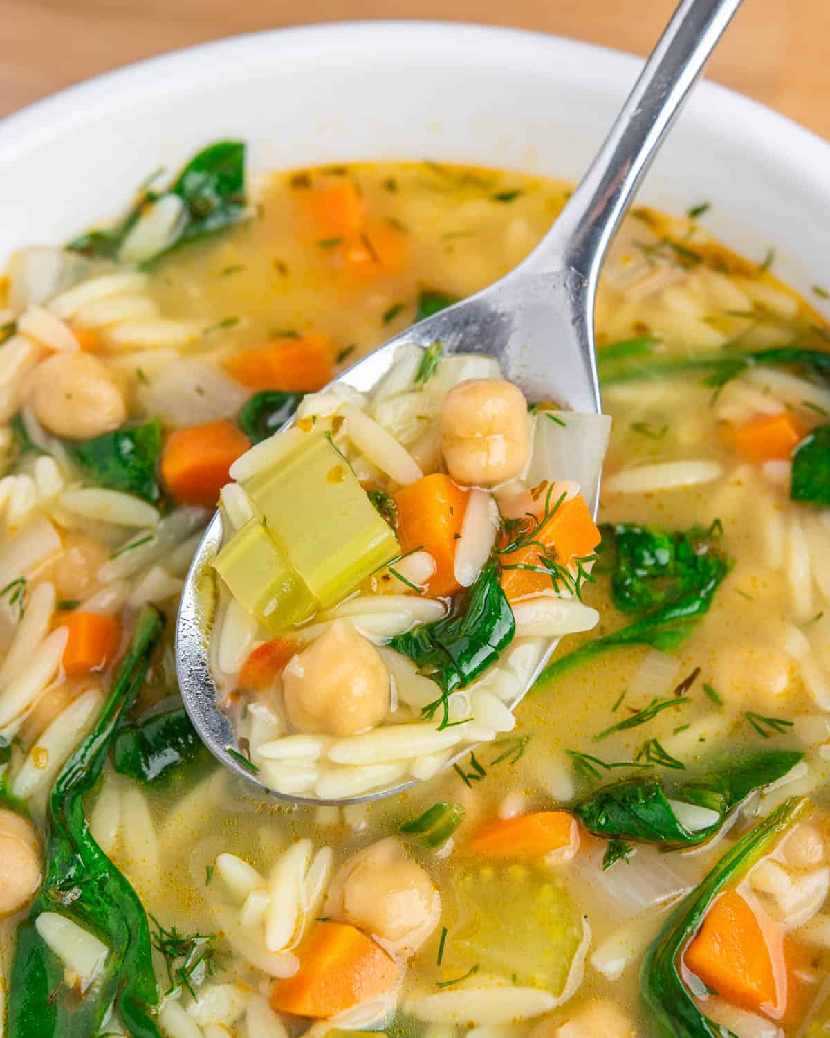 close-up of a spoonful of lemon chickpea orzo soup