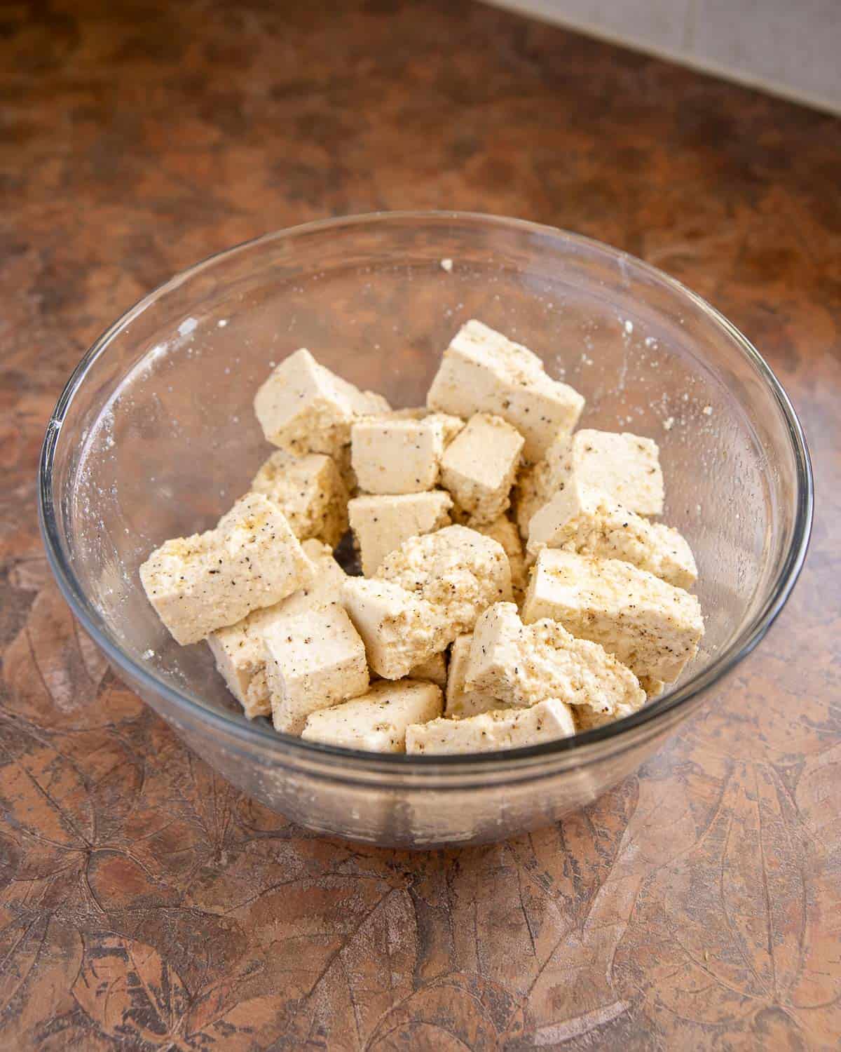 bowl of tofu tossed in oil and spices