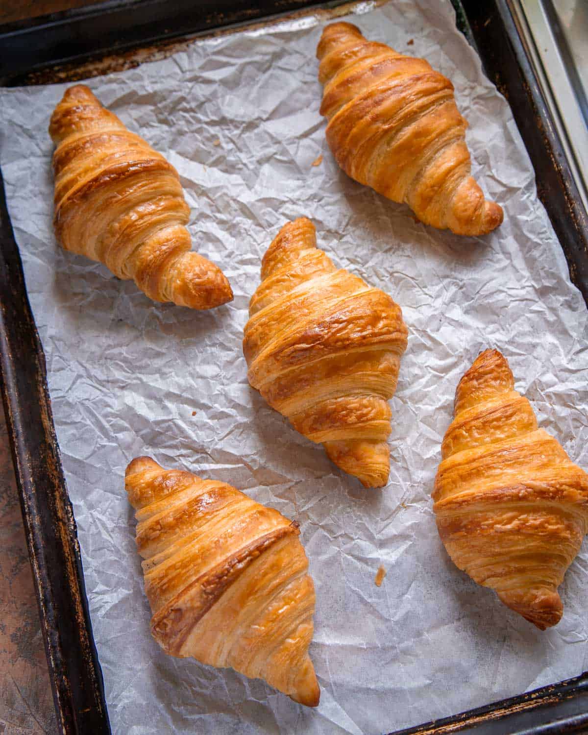 vegan croissants laid out on a parchment-lined baking tray