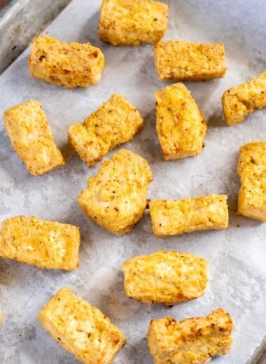pieces of crispy baked tofu on a lined baking tray
