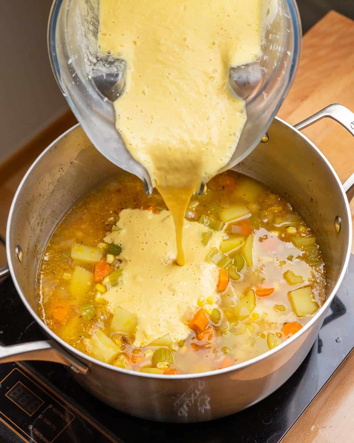 Adding blended soup back into the soup pot.