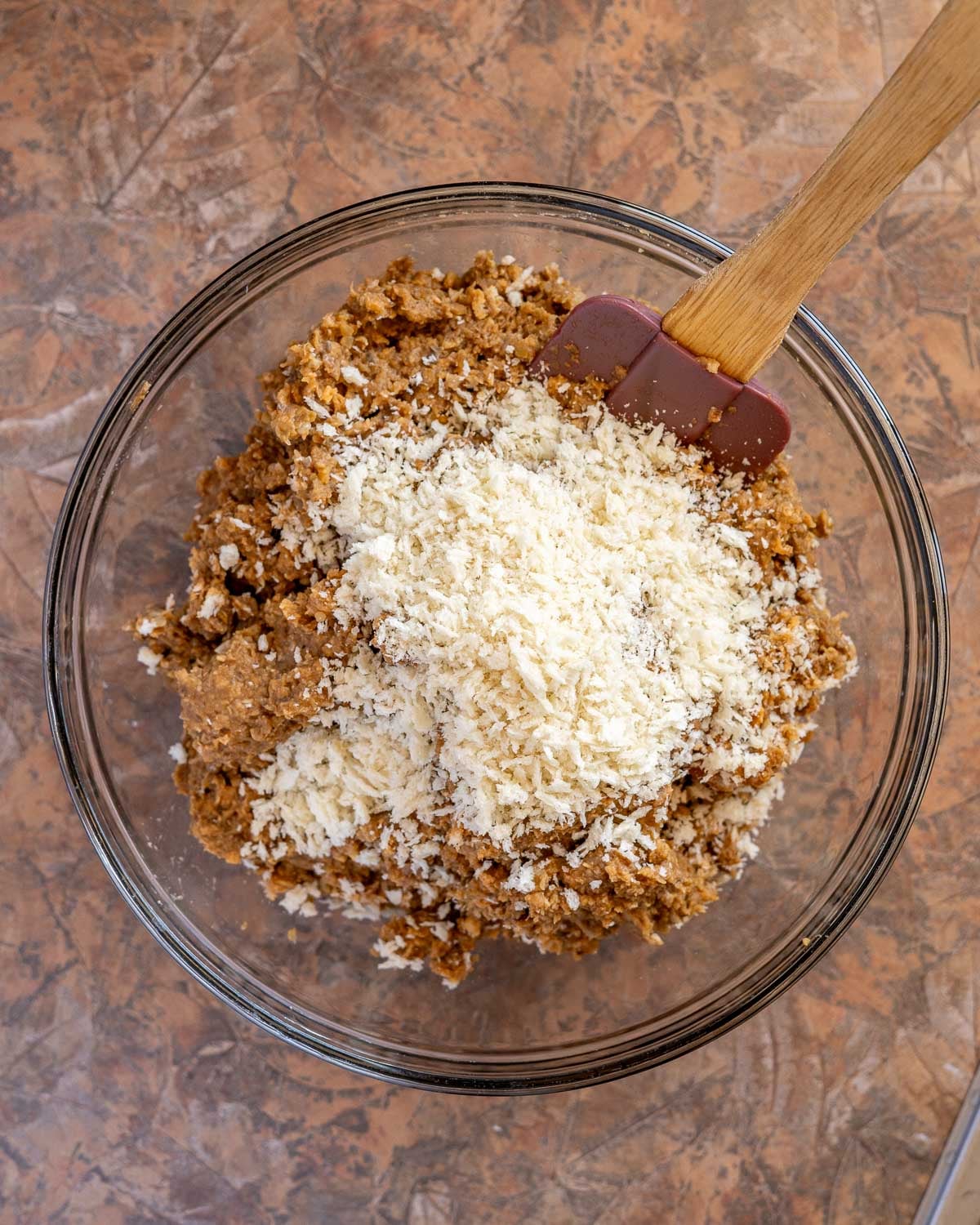 Ingredients for lentil burgers in a bowl with breadcrumbs added.
