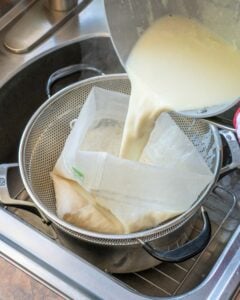 Pouring cooked soymilk into nut milk bag