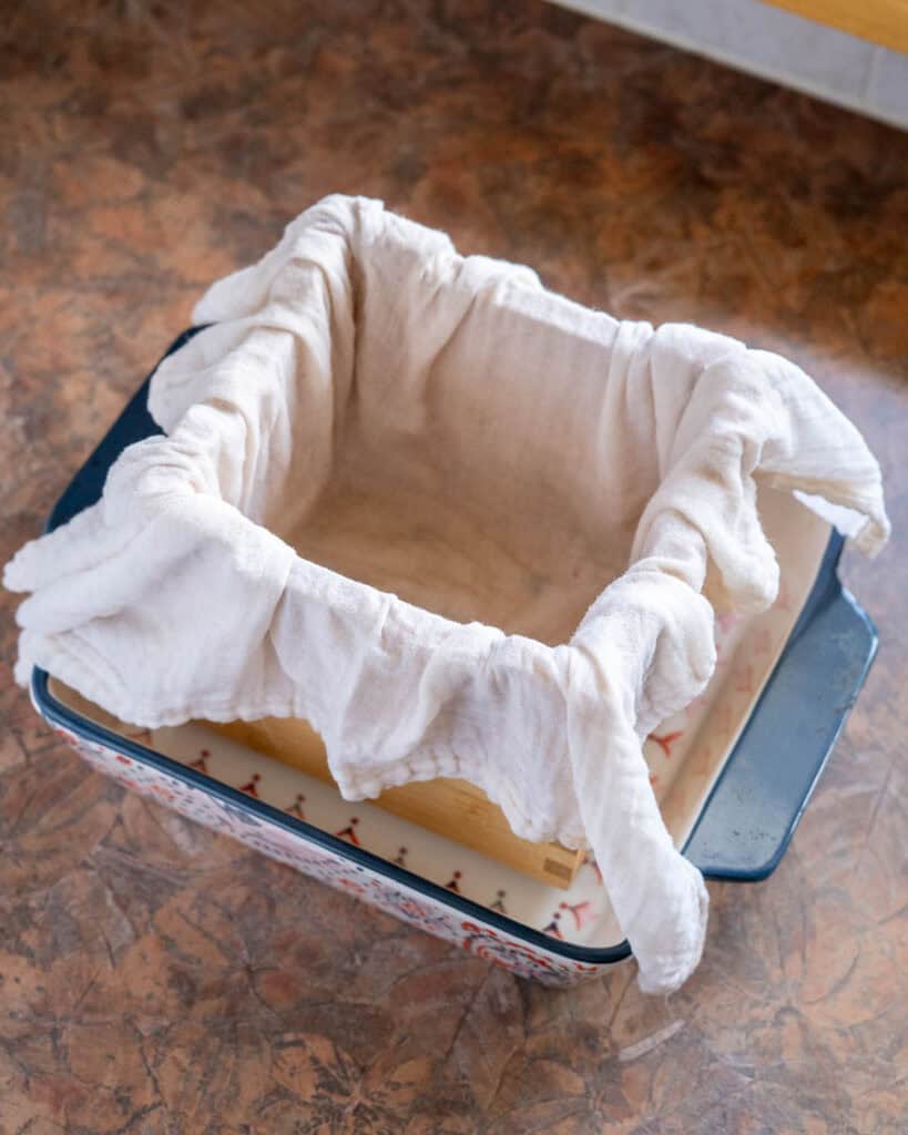 Tofu mold lined with moistened cheesecloth