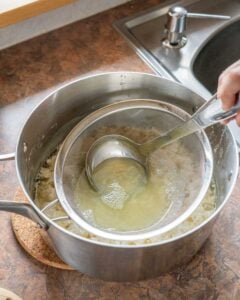 Skimming extra liquid out of the pot