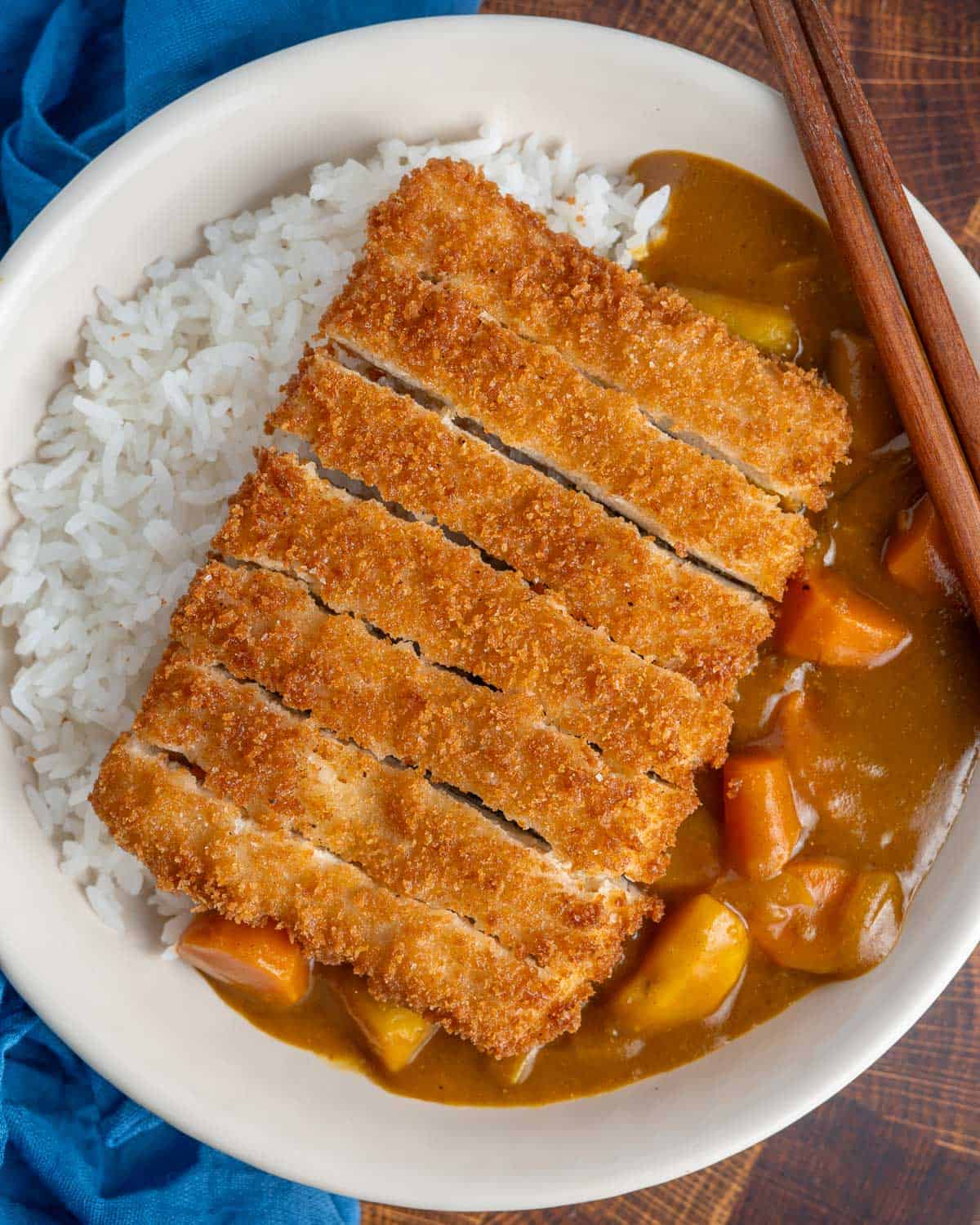 Sliced tofu katsu cutlet on top of Japanese curry and white rice.
