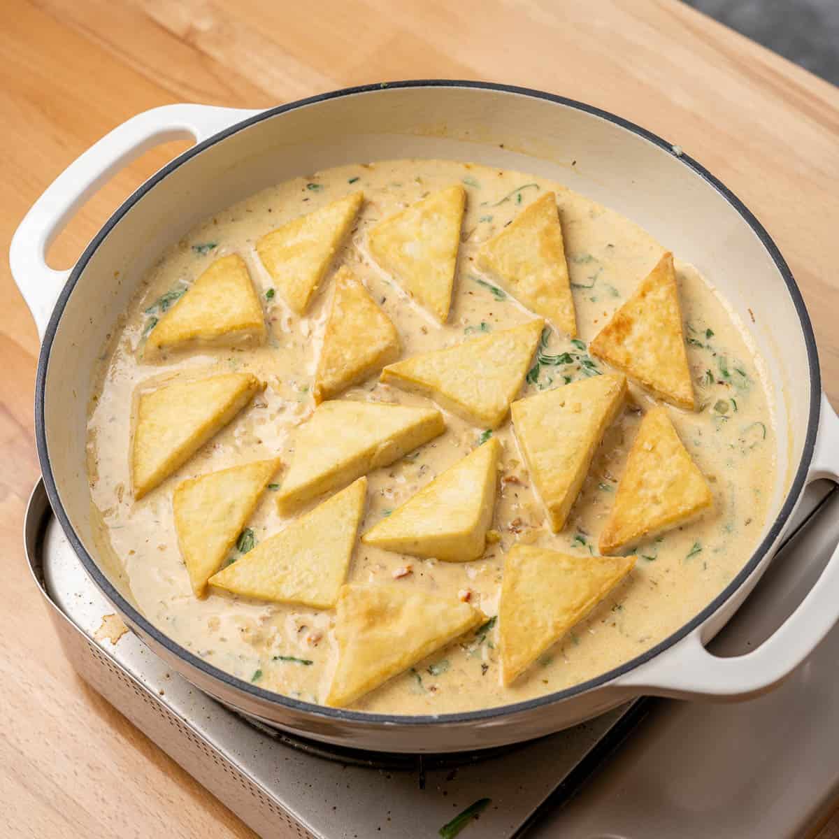 fresh basil and tofu triangles added into the pan