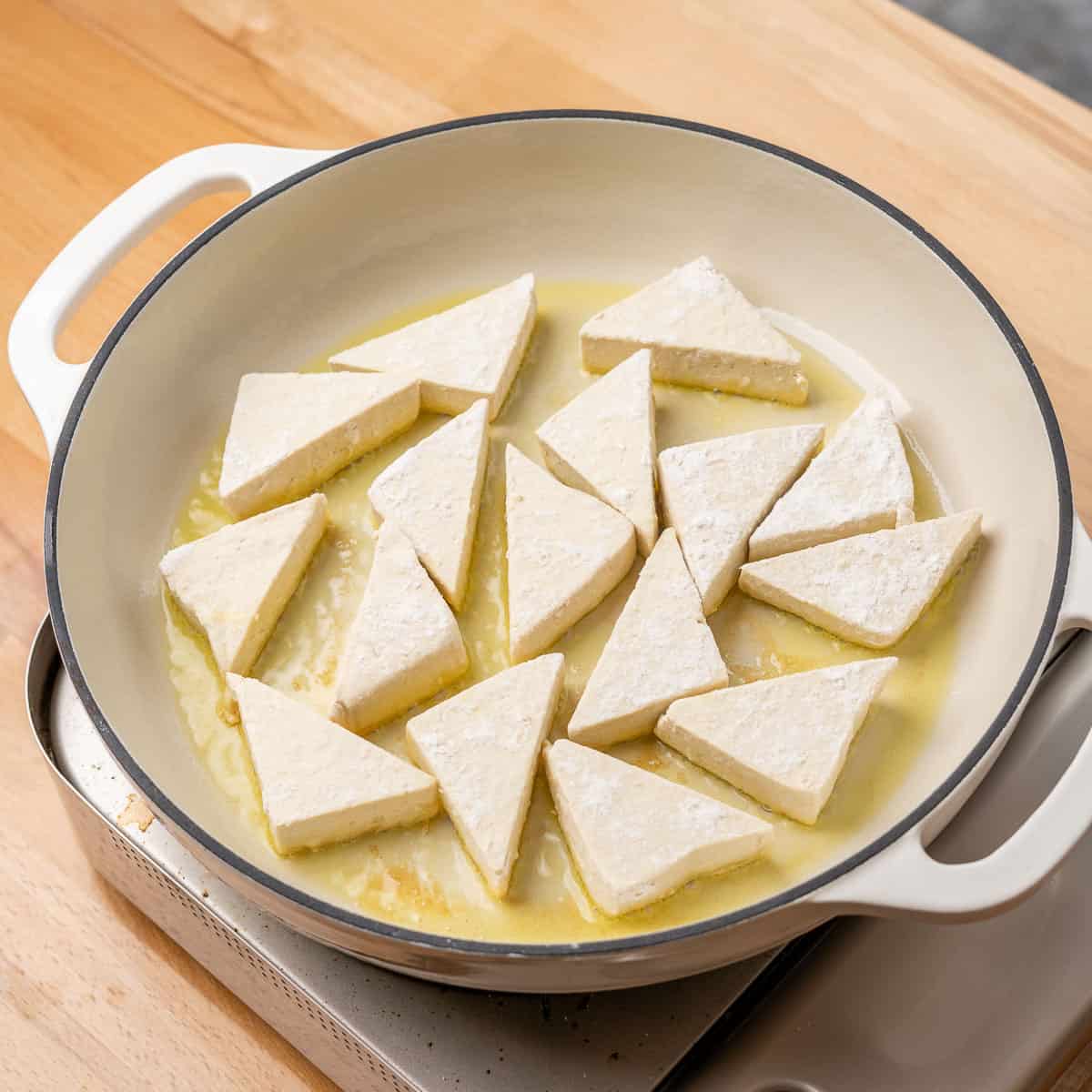 Dredged tofu frying in olive oil