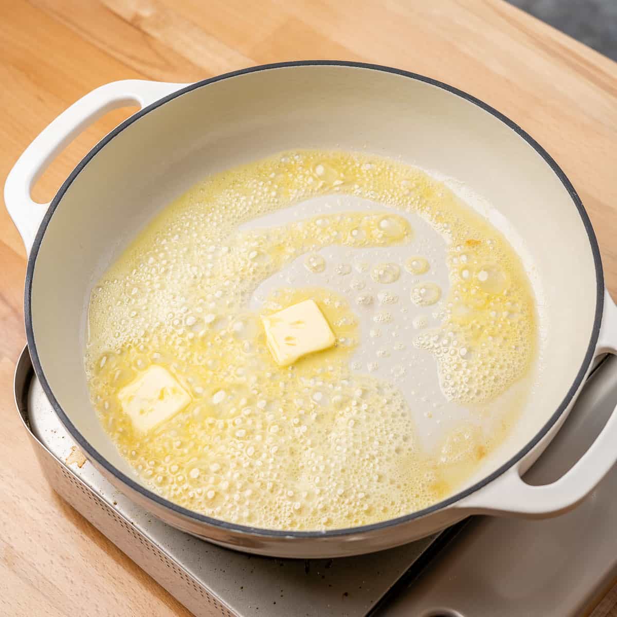 butter and oil, bubbling in a white braiser pan
