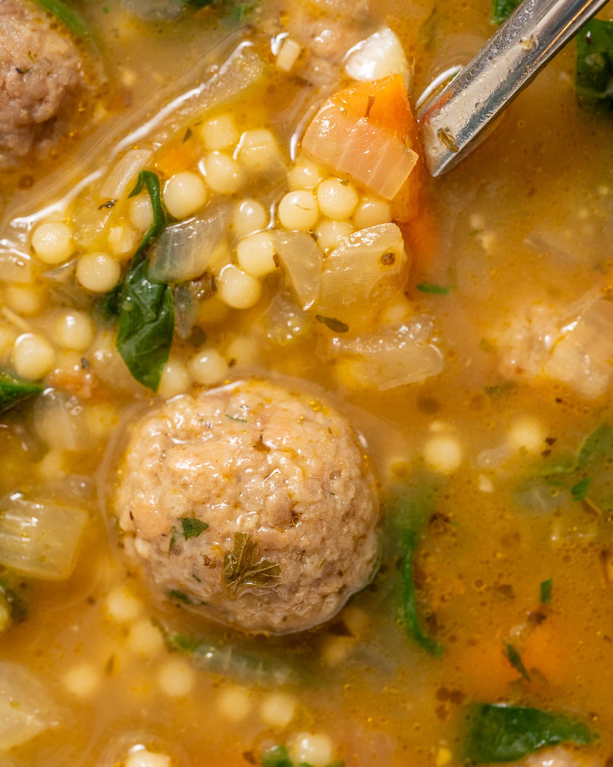 closeup shot of Italian wedding soup in a bowl to show texture of meatball