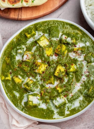 bowl of vegan palak paneer with rice and naan