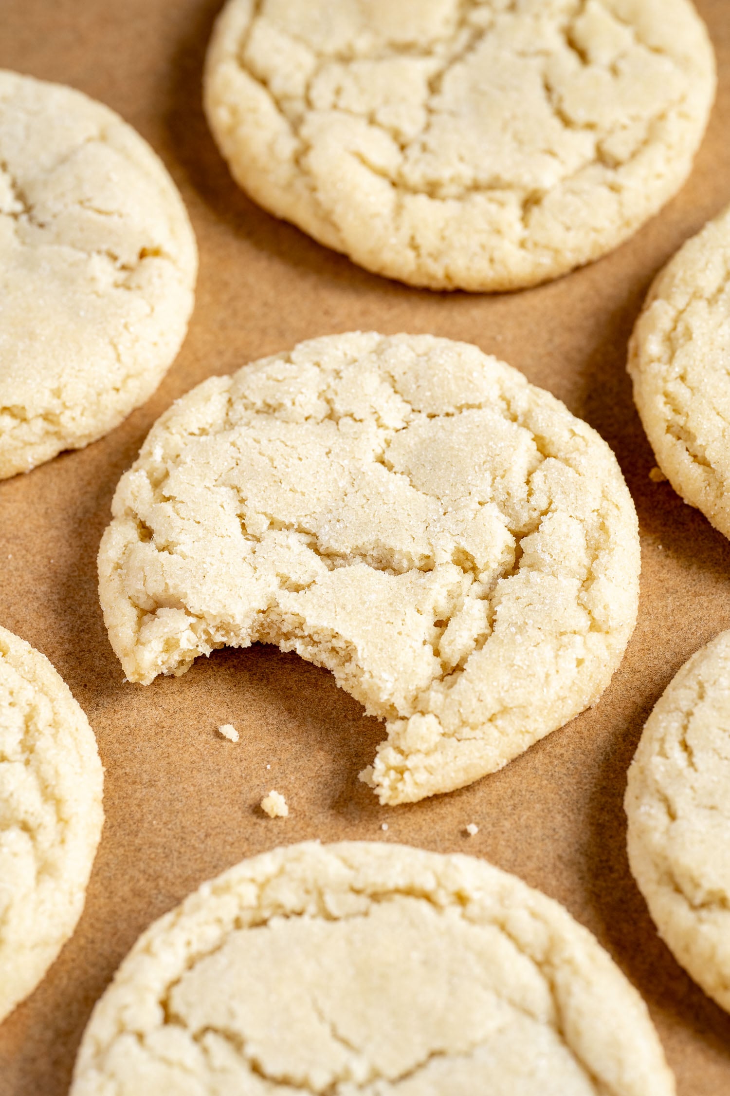 a tray of vegan sugar cookies, with a bite taken out of the middle one