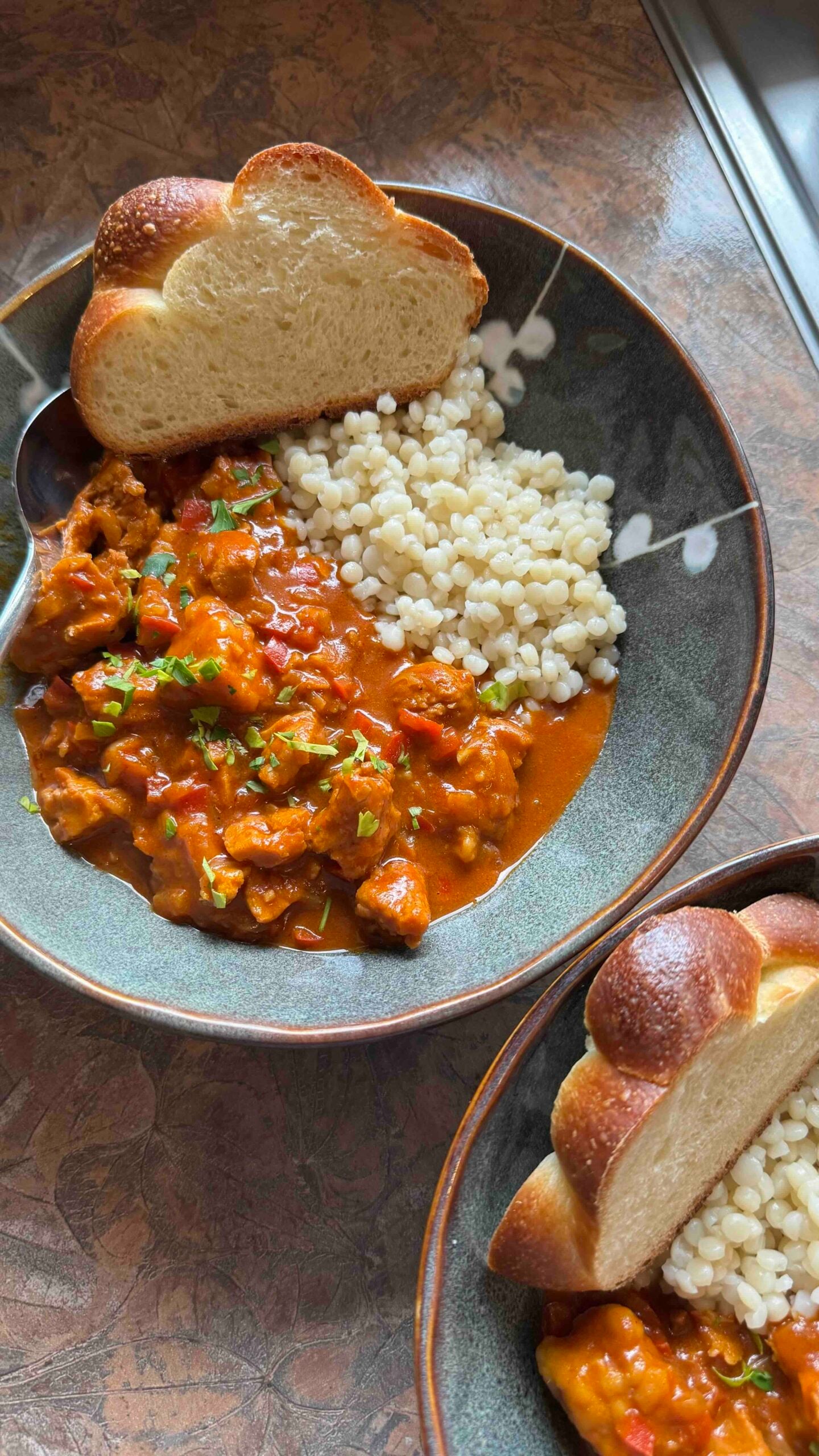 two bowls of vegan chicken paprikash, served with orzo and challah