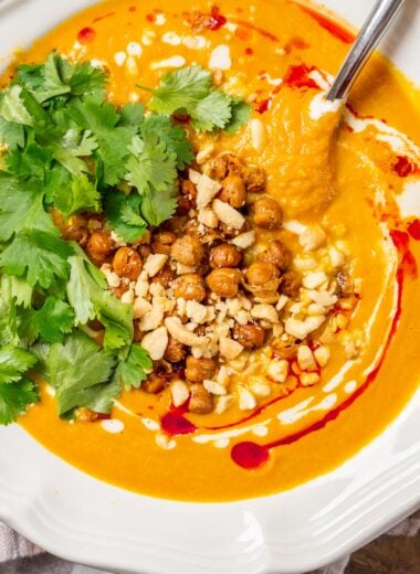 creamy carrot ginger soup with crispy chickpeas, peanuts and cilantro