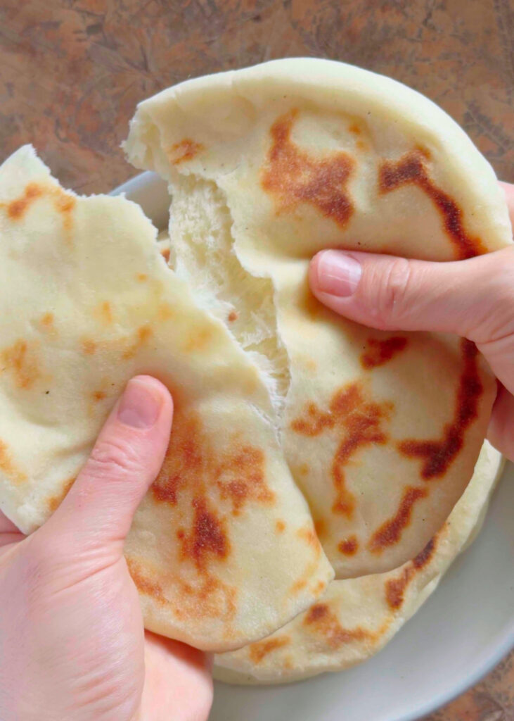 tearing a fresh pita in half