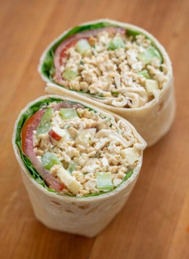 wrap filled with vegan chicken salad, lettuce, and tomato