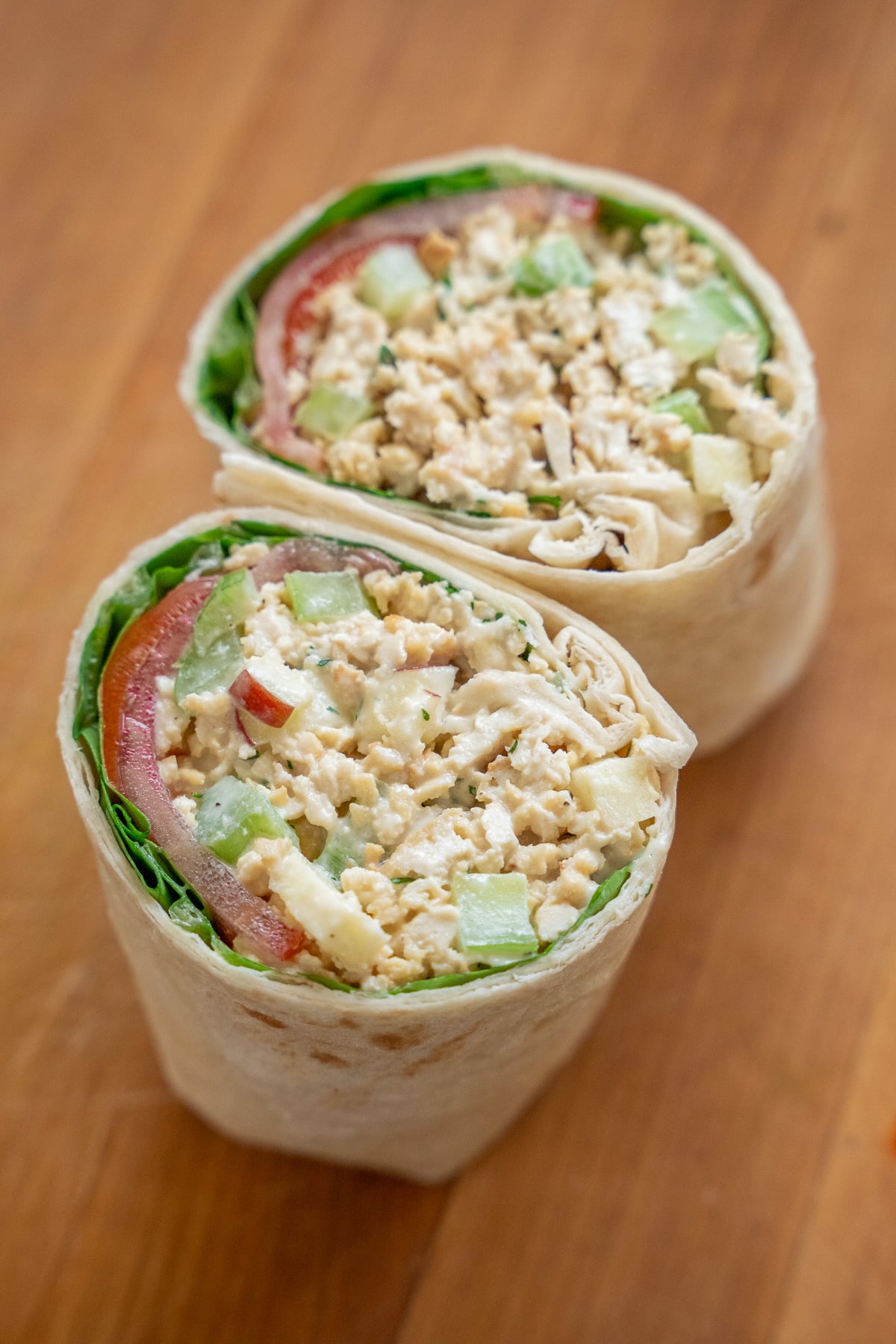 wrap filled with vegan chicken salad, lettuce, and tomato